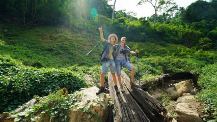 Traveller smiling with lush green forest behind them on a hilltribe trek in Mae Taeng, Chiang Mai, Thailand