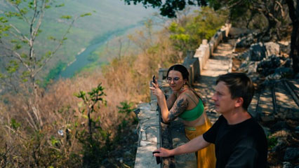 Travellers laughing with a local playing guitar during a hilltribe village homestay in Mae Taeng District, Thailand